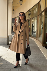 a lady wears a trench coat with black flared jeans